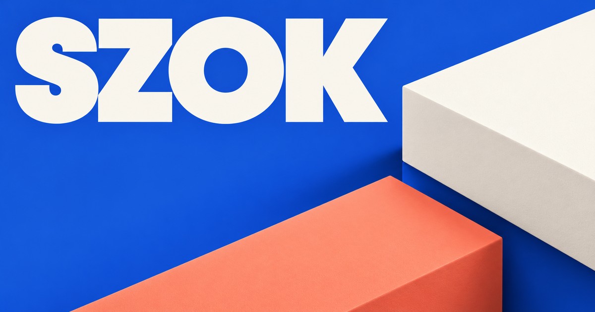Duży jasny napis SZOK na kobaltowym tle; dwie matowe geometryczne bryły oddzielone wąską pustą przestrzenią.